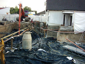 Zwischen die Eisenträger (links) kommen Holzbalken - so entsteht eine Stützmauer.